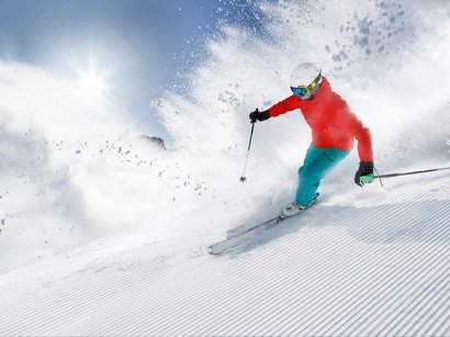Lo skilift per famiglie con vista Dolomiti Sciatore scende velocemente sulla neve fresca con il sole splendente