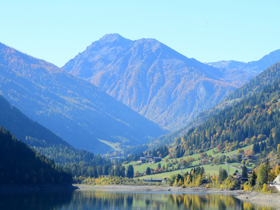 Lago di Zoccolo in Val d’Ultimo Lago di montagna con foresta e baite in autunno sotto cielo sereno