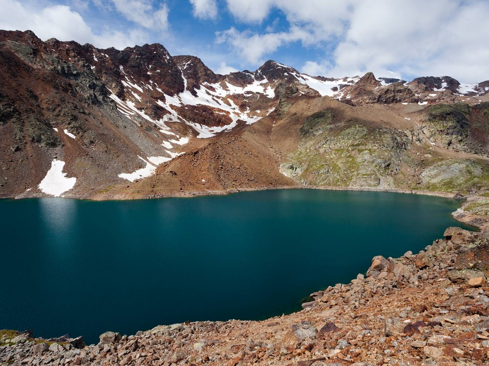 Il Lago di Gioveretto in Val Martello Lago di montagna con cime innevate e paesaggio roccioso