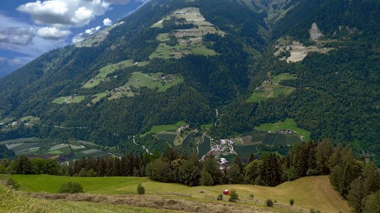 Hotels Saltaus im Passeiertal Berglandschaft mit Tal, Wäldern und Feldern unter blauem Himmel mit Wolken