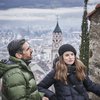 Hotel in Alto Adige 😎☀️ Per vacanze indimenticabili Coppia con abbigliamento invernale davanti a una città con torre della chiesa sullo sfondo