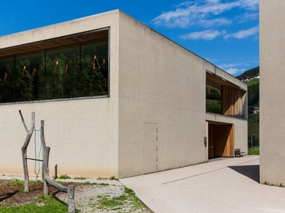 Museo contadino a Sant’Osvaldo Edificio moderno con ampie finestre e area giochi in legno esterna