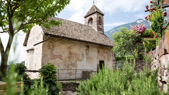 Castel d’Appiano, nel cuore dell’Alto Adige Antica cappella con affreschi nel verde davanti a paesaggio montano