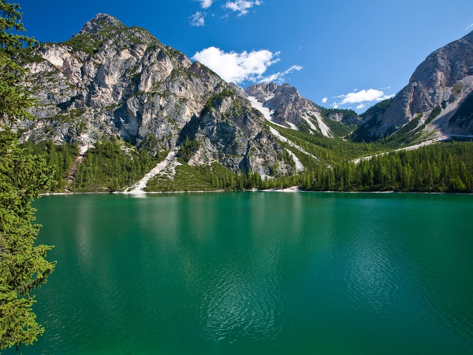 Der Pragser Wildsee im Hochpustertal in Südtirol Bergsee mit grünen Tannen, Bergen und blauem Himmel