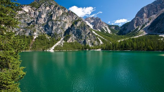 Il Lago di Braies in Alta Pusteria in Alto Adige Lago di montagna con pini verdi, montagne e cielo azzurro