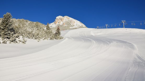 Jochgrimm: klein, aber oho! Frische präparierte Skipiste mit Sessellift und Berg im Hintergrund