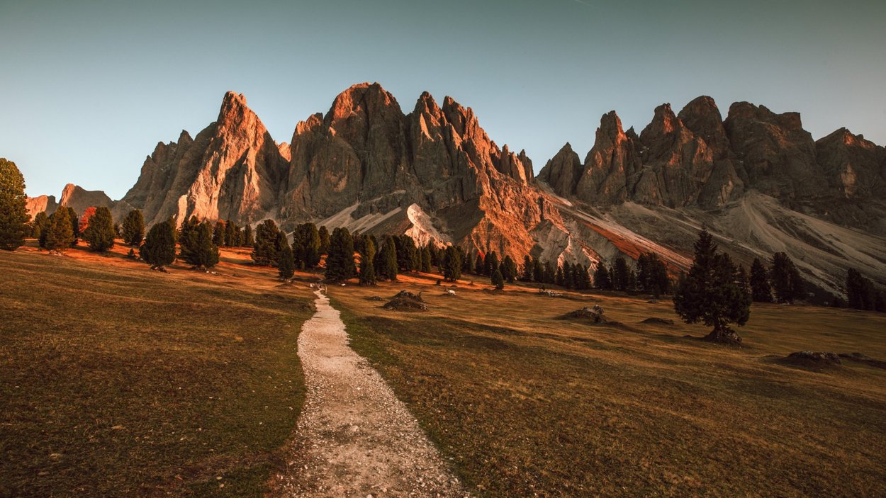 Panorama da sogno dal Rifugio delle Odle Sentiero in montagna con rocce illuminate dalla luce calda del tramonto