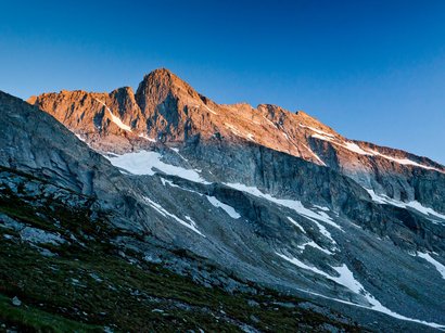 Die Natur in und um Südtirol Berggipfel im Sonnenuntergang mit Schneeflecken und blauem Himmel