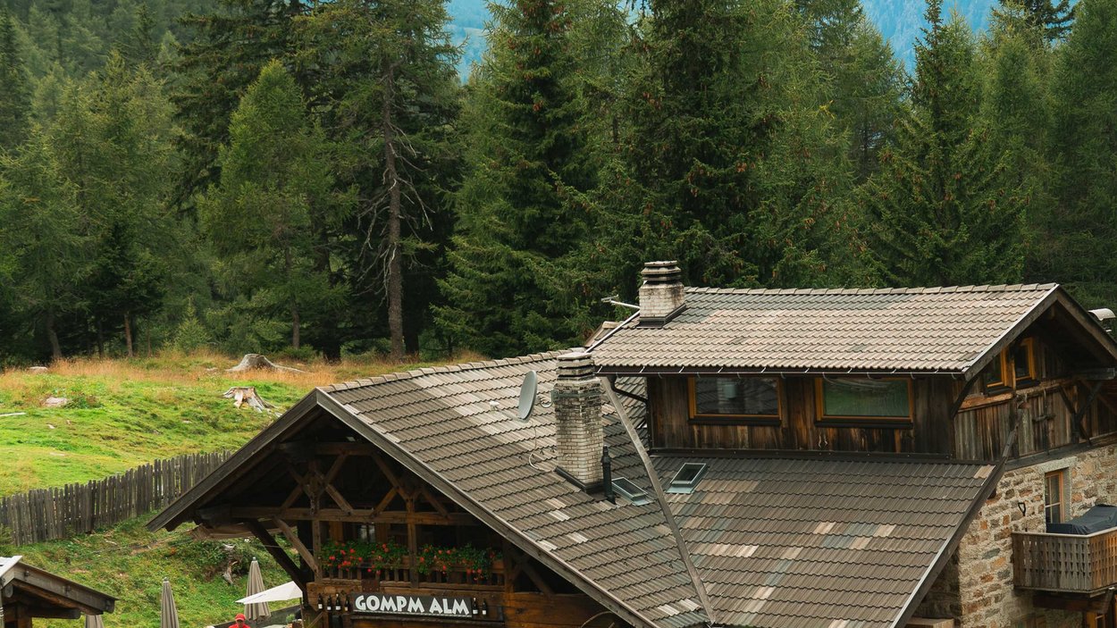 Echt Südtirol: Almen Berghütte mit Außenterrasse und Bergen im Hintergrund