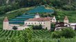 Schloss Goldrain Historisches Schloss umgeben von Obstplantagen und Weinbergen in grüner Landschaft