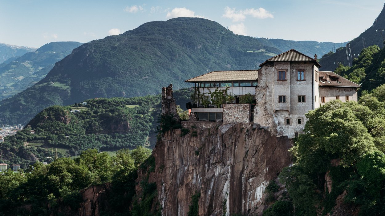 Castel Flavon a Bolzano Antico castello su scogliera con montagne boschive sullo sfondo