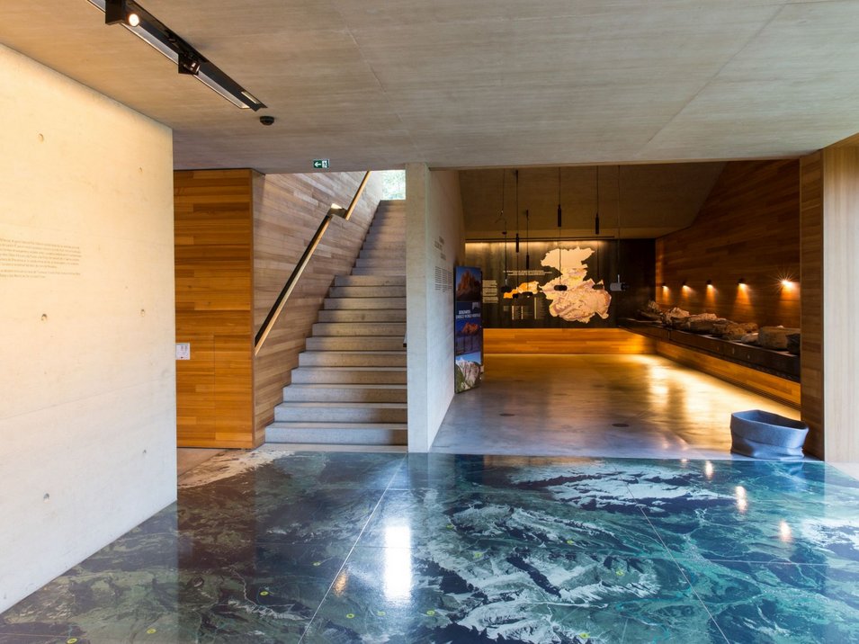 Centro visite Puez-Odle Sala espositiva moderna con mappa del territorio su pavimento e parete e scala