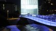 Das Museion in Bozen Beleuchtete moderne Brücke über einen Fluss bei Nacht mit blauem Licht