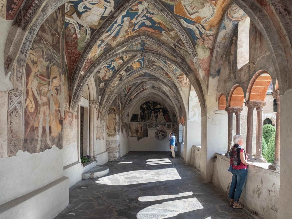 Hotels in Brixen, Südtirol, der ältesten Stadt Tirols Mittelalterlicher Kreuzgang mit bemalten Gewölben und zwei Besuchern