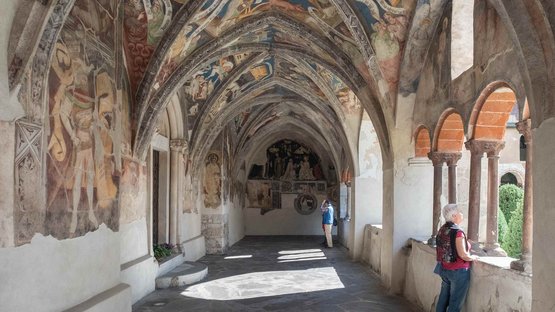 Hotels in Brixen, Südtirol, der ältesten Stadt Tirols Mittelalterlicher Kreuzgang mit bemalten Gewölben und zwei Besuchern