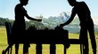 Gourmet-Urlaub in Südtirol: Genuss pur Silhouetten von Kellnern beim Decken eines Tisches mit Bergblick