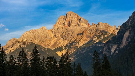 La montagna più alta delle Dolomiti di Braies Catena montuosa al tramonto con alberi di conifere in primo piano