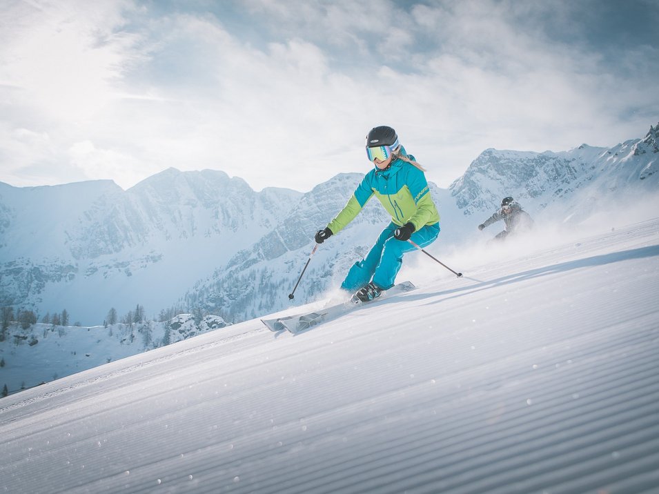 Il vostro paradiso per famiglie Due sciatori scendono una pista innevata tra le montagne