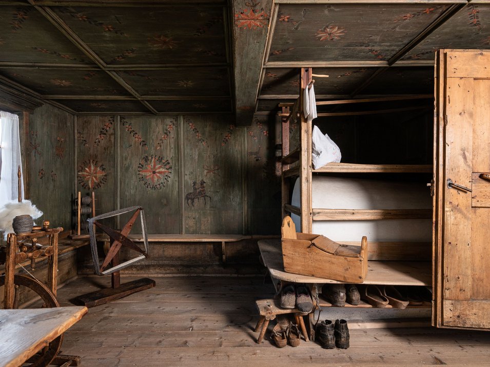 Il museo provinciale degli usi e costumi Stanza storica con pareti dipinte a mano, filatoio e armadio in legno con letti