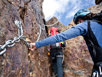 Klettern im Rosengarten: Rotwand- und Masarè-Klettersteig Kletterer sichern sich an Metallketten beim Aufstieg auf felsigem Gelände