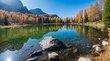 In giro per le Dolomiti Lago di montagna autunnale con riflessi nitidi di alberi colorati e rocce nell'acqua