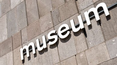 Museo Mansio Sebatum Insegna museo bianca su parete di pietra grigia