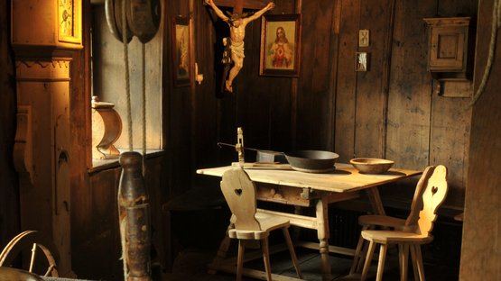 Il Museum Ladin Ćiastel de Tor Stanza storica con telaio per tessere e sedie di legno davanti a un tavolo in legno