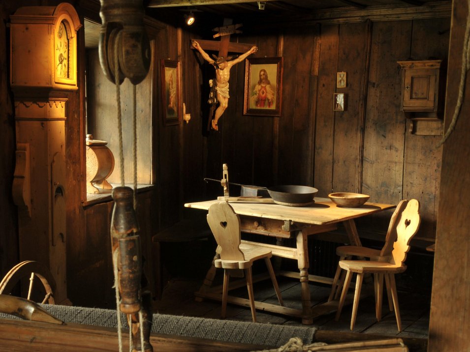 Il Museum Ladin Ćiastel de Tor Stanza storica con telaio per tessere e sedie di legno davanti a un tavolo in legno
