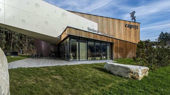 Hotel a Vandoies Edificio moderno con facciata in legno e grandi pietre su prato verde