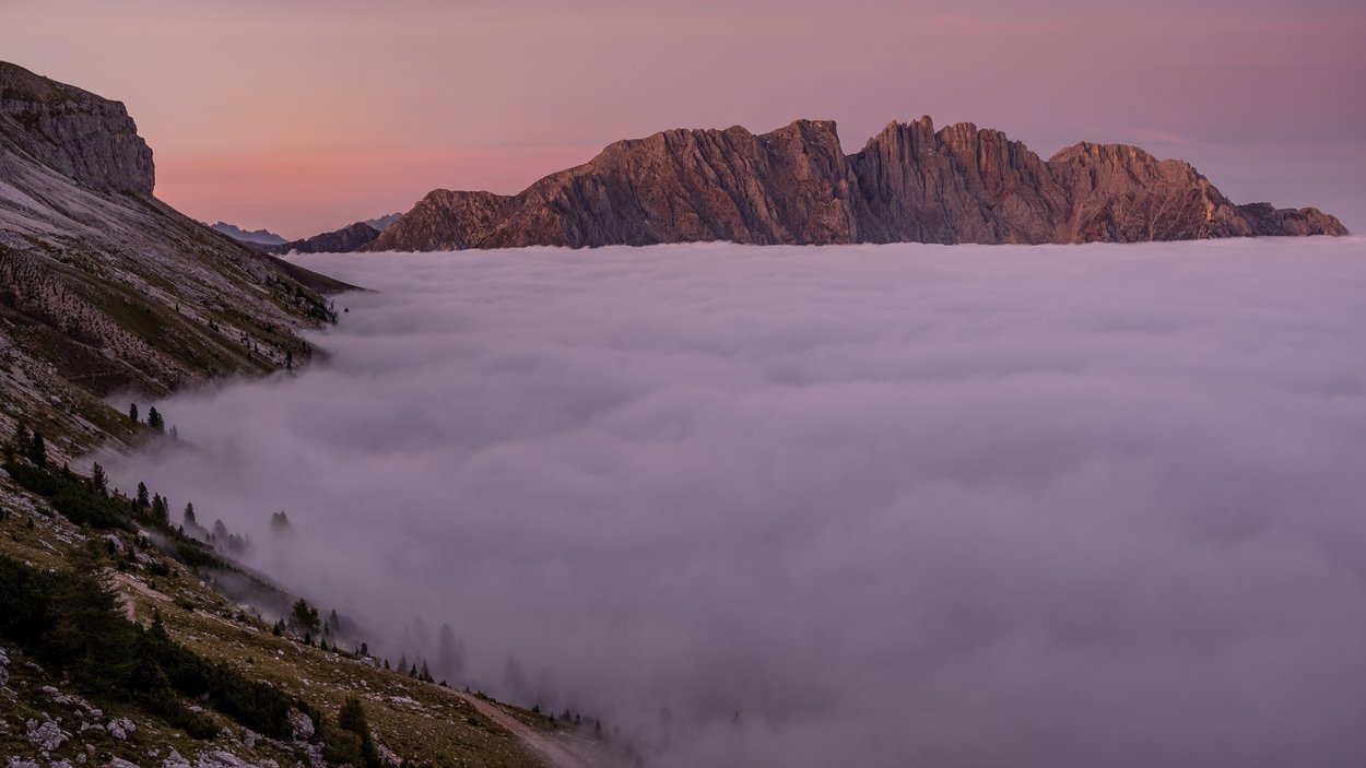Il Latemar: il gigante dolomitico solitario Cime montuose sopra un mare di nuvole al tramonto