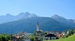 Hotel a Valdaora in Alta Pusteria Villaggio con chiesa davanti a montagne verdi e cielo azzurro