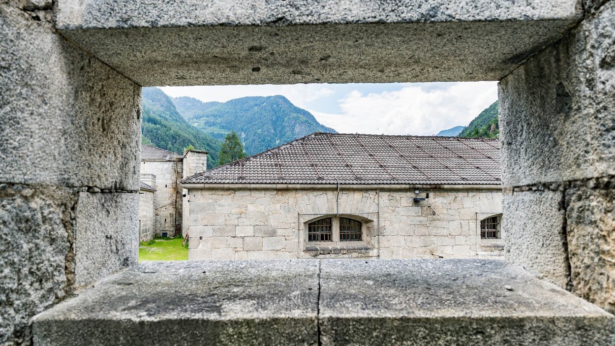 Il forte di Fortezza Vista attraverso feritoia su edificio e montagne sullo sfondo