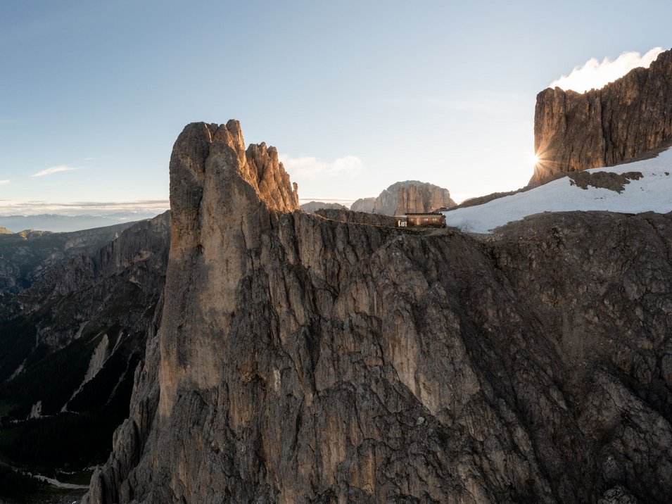 Il regno di Re Laurino Alba dietro rocce e baita in montagna con neve sulle pendici