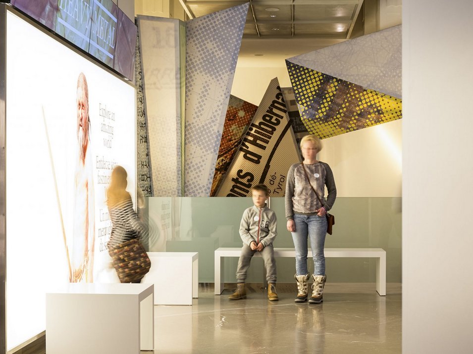 Il Museo Archeologico dell’Alto Adige Persone in mostra museale moderna con schermo luminoso e banner