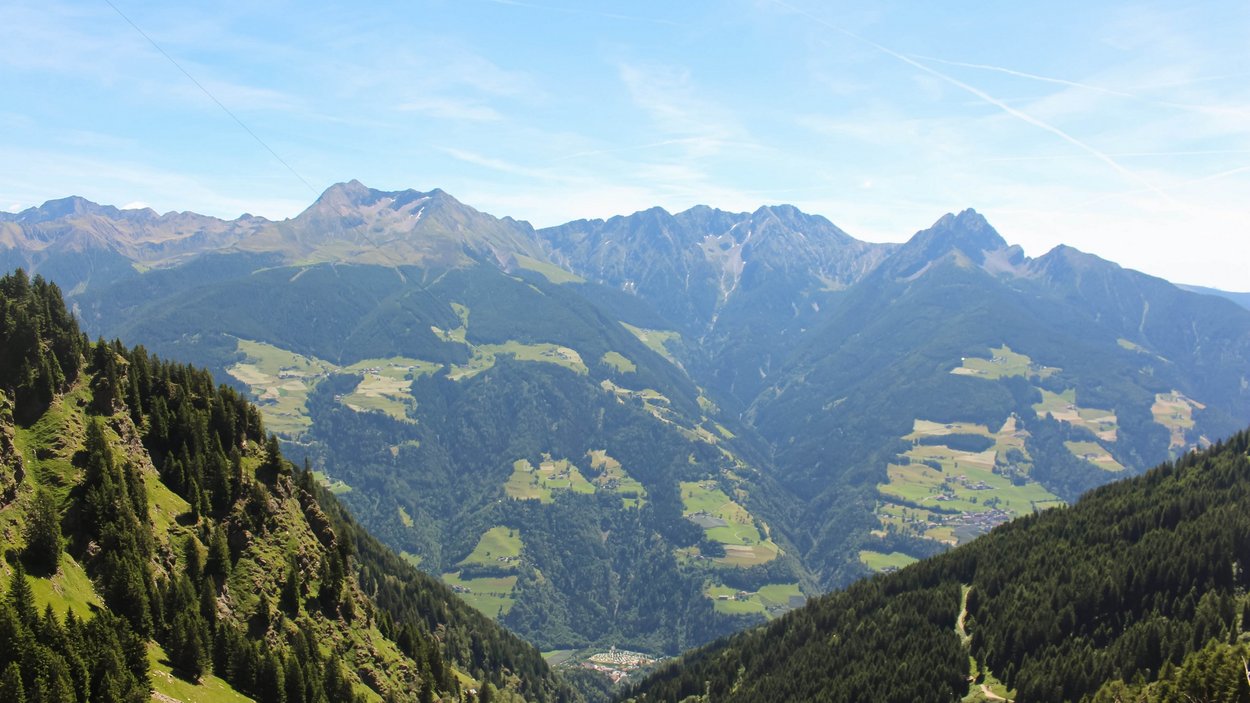 Hotels Saltaus im Passeiertal Berglandschaft mit grünen Wäldern und Dörfern unter blauem Himmel
