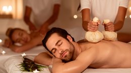 ABINEA Dolomiti Romantic SPA Hotel Paar erhält entspannende Rückenmassage mit Kräuterstempeln im Spa