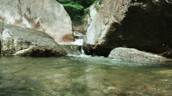 La splendida cascata Passiria a S. Martino Acqua limpida scorre tra grandi rocce e alberi verdi nella foresta