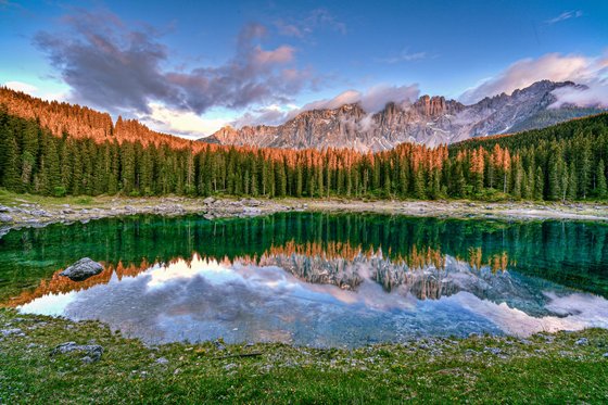 Trentino-Südtirol entdecken Bergsee mit Spiegelung von Wald und Bergen bei Sonnenuntergang