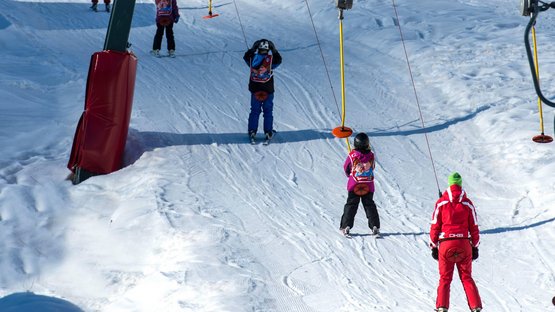 Tanto esercizio a Fleres di Dentro Bambini che sciano su impianto di risalita in giornata soleggiata