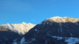 Ihre Hotels in Meran in Südtirol: Hotels im Meraner Land Schneebedeckte Berge unter klarem blauen Himmel mit sichtbarem Mond