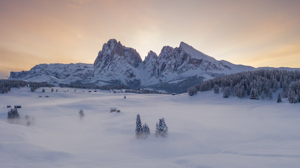 Alpe di Siusi – Sci di fondo sull’altopiano più grande d’Europa Montagne innevate, alberi e nebbia al tramonto in valle