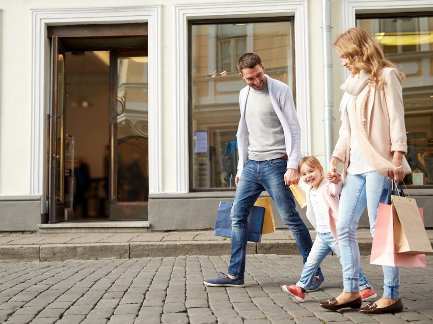 Hotel in Alto Adige 😎☀️ Per vacanze indimenticabili Famiglia che cammina ridendo con borse della spesa su lastricato