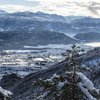 Hotel in Alto Adige 😎☀️ Per vacanze indimenticabili Valle innevato con villaggio, montagne e lago sullo sfondo con cielo nuvoloso