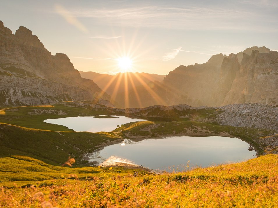 Escursioni sulle Dolomiti di Sesto Tramonto su due laghi di montagna e prato fiorito nelle Alpi