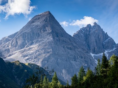 Von Südtirol nach Österreich über den Wilden Freiger Große felsige Berge mit teilweise schneebedeckten Gipfeln und Wald im Vordergrund