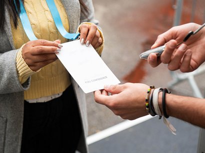 Hotel ad Appiano sulla Strada del Vino Persona mostra un badge con scritto Full Conference al controllo accessi