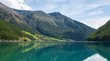 Il Lago di Vernago, il paradiso dei pescatori Lago di montagna con acqua limpida e riflesso delle montagne e boschi sotto il cielo blu