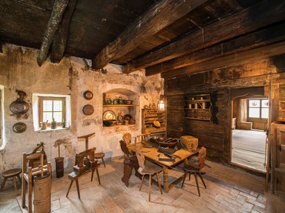 Tesoro del Duomo di Bolzano Cucina rustica antica con sedie in legno e utensili da cucina