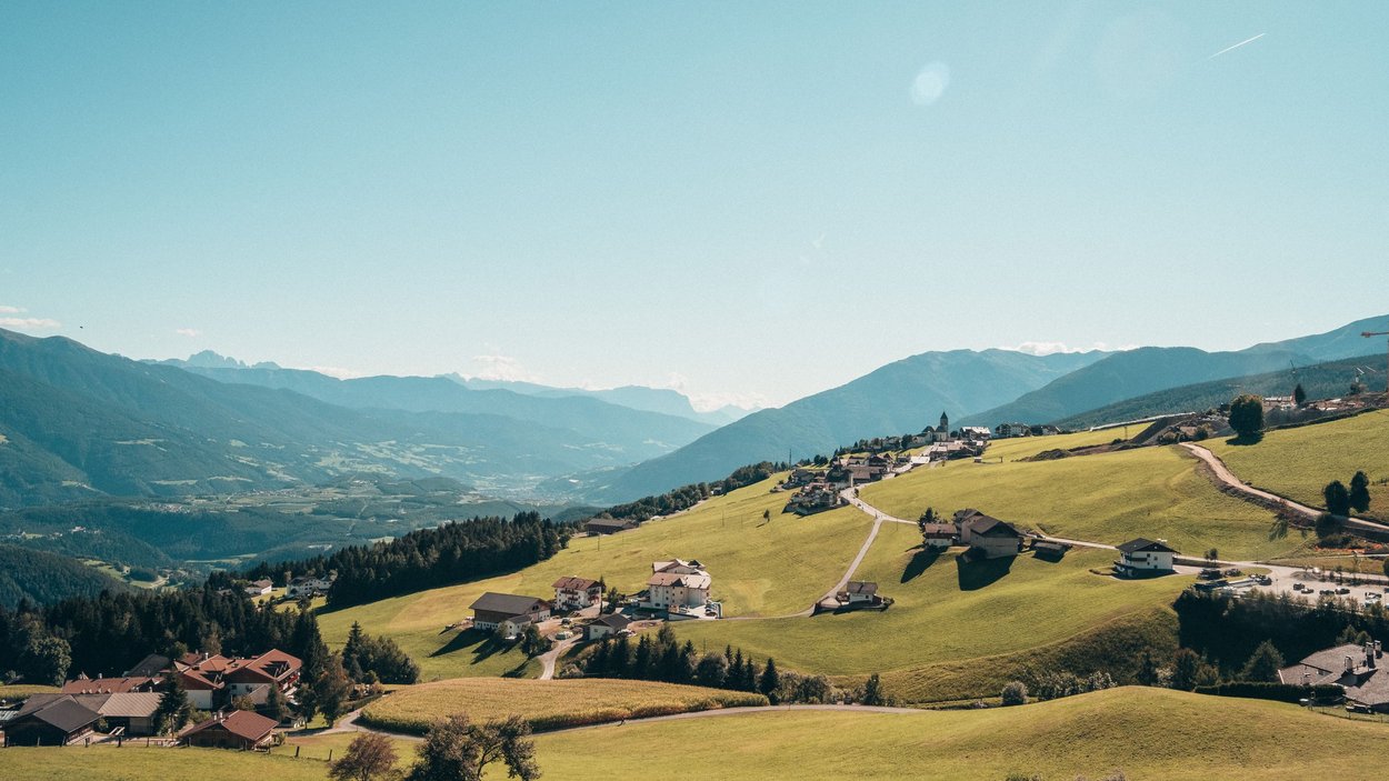 Hotel a Maranza in Alto Adige Villaggio di montagna con prati verdi e montagne sullo sfondo cielo limpido