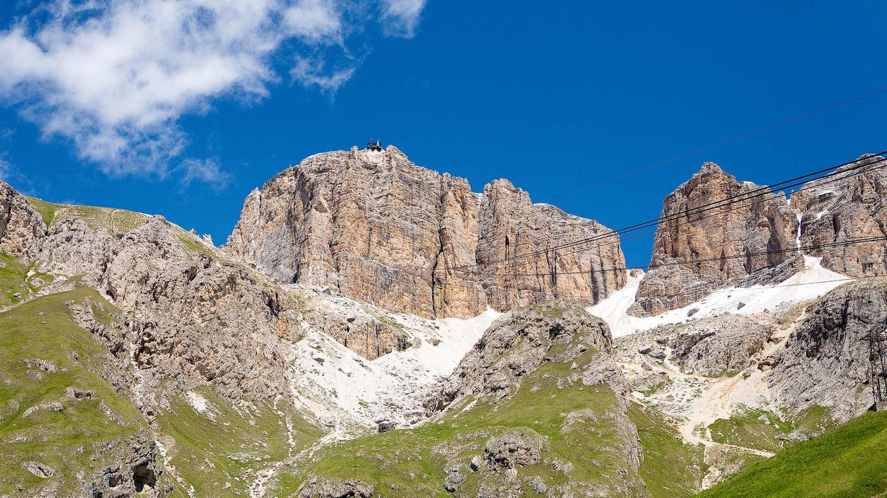 Passo Pordoi Montagne rocciose con prati verdi e cielo blu limpido sopra